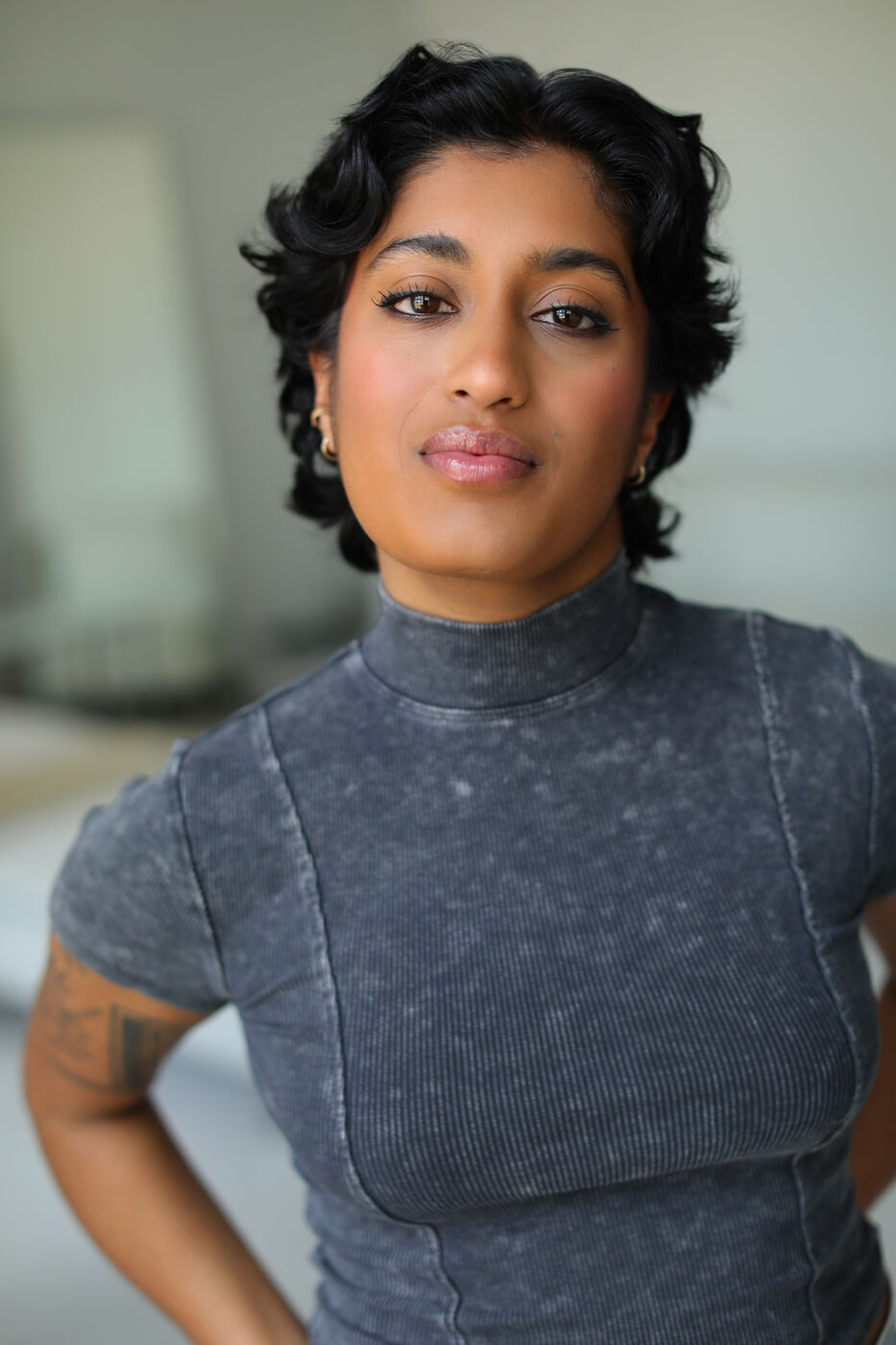 Headshot of Uma Paranjpe — grey mock-neck, soft smile