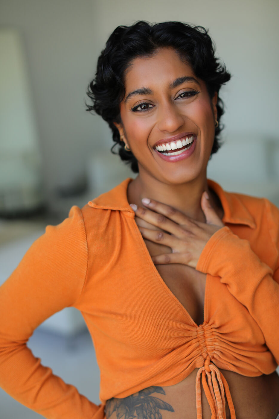 Headshot of Uma Paranjpe — bright laugh, hand on chest