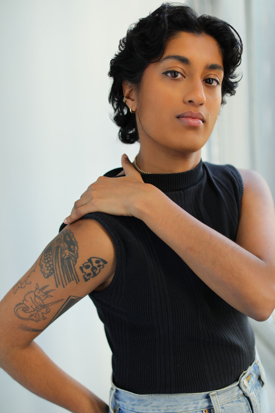 Headshot of Uma Paranjpe — black tank, hand on shoulder