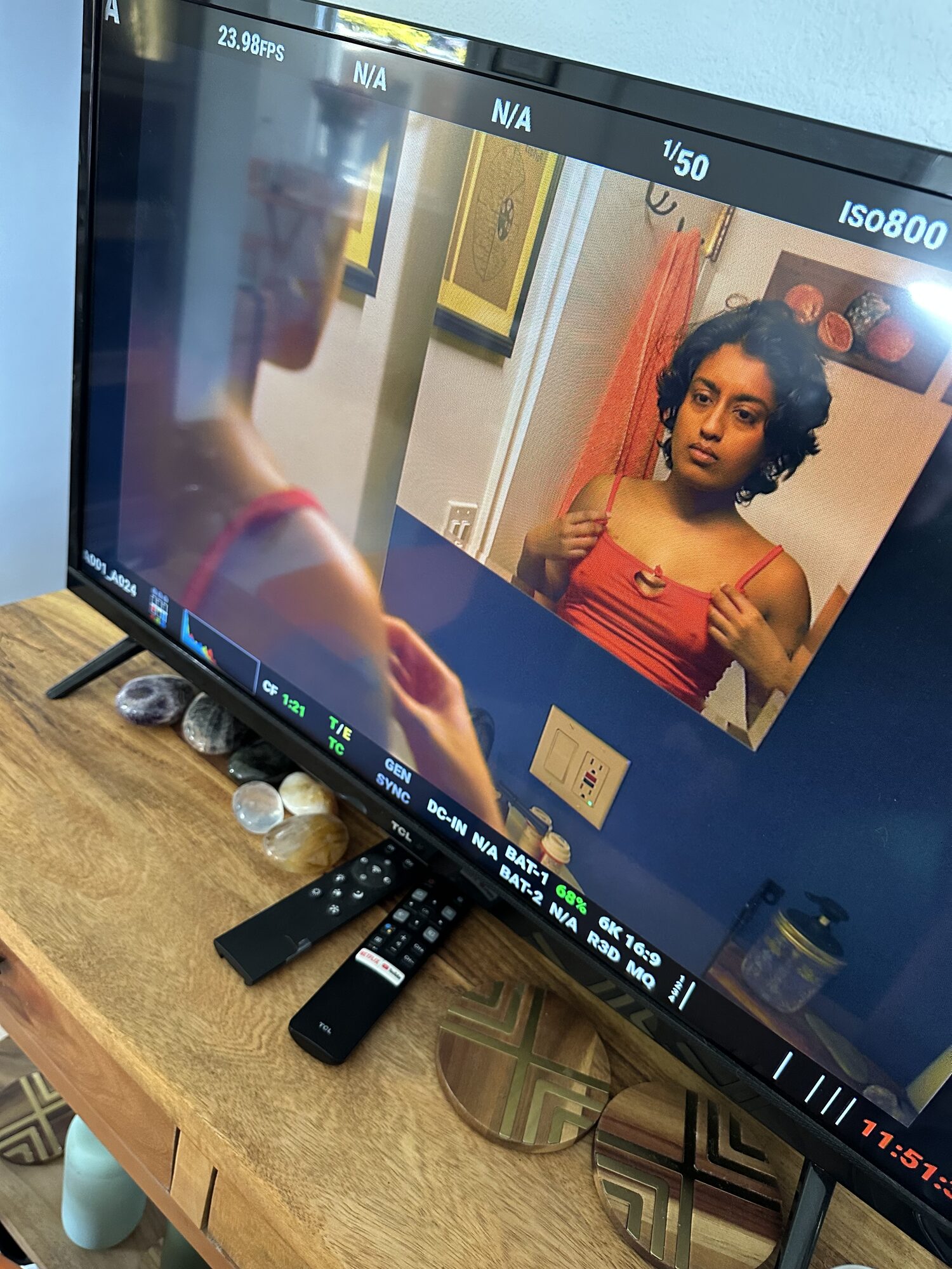 Monitor view of Uma in a red top during a take