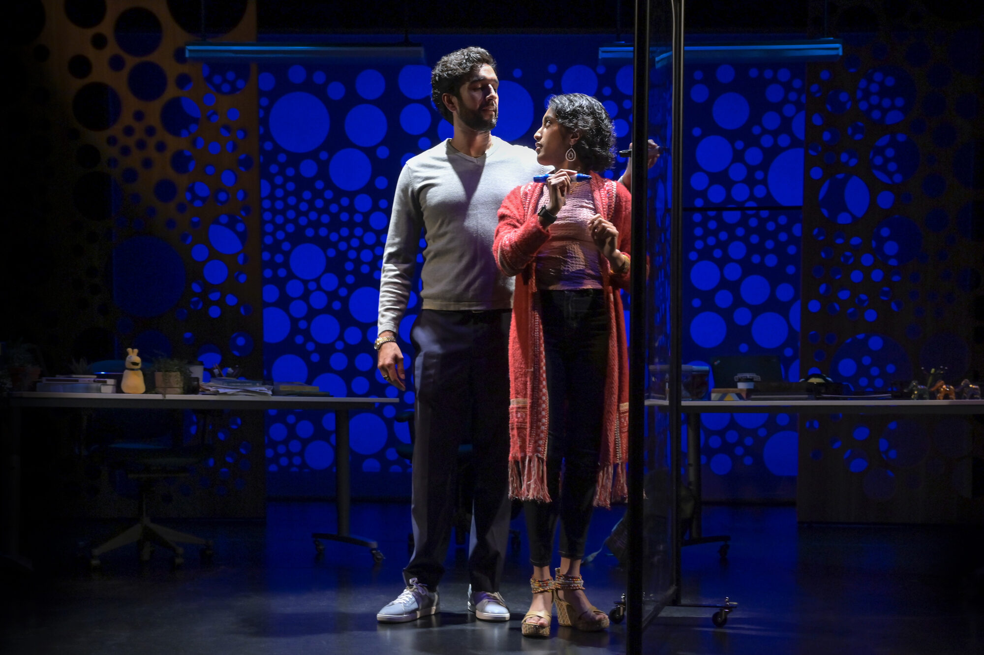 Two actors on a blue dotted set in Queen